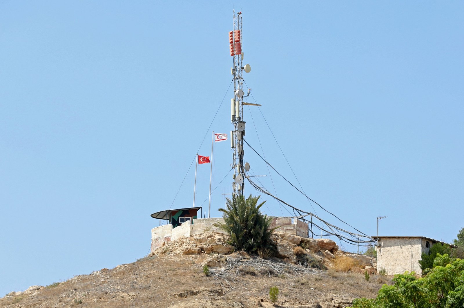 Turkish and Turkish Republic of Northern Cyprus (TRNC) flags flutter in Pile village, which lies between the Greek Cypriot administration in the south and the TRNC in the north, Aug. 20, 2023. (AFP Photo)