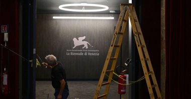 A worker paints a door at the Palazzo del Casino where journalists gather on the eve of the 80th Venice Film Festival, Venice, Italy, Aug. 29, 2023. (AFP Photo)