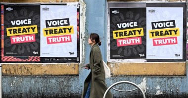 A woman walks past posters advocating for an Aboriginal voice and treaty ahead of an upcoming referendum, Melbourne, Australia, Aug. 30, 2023. (AFP Photo)