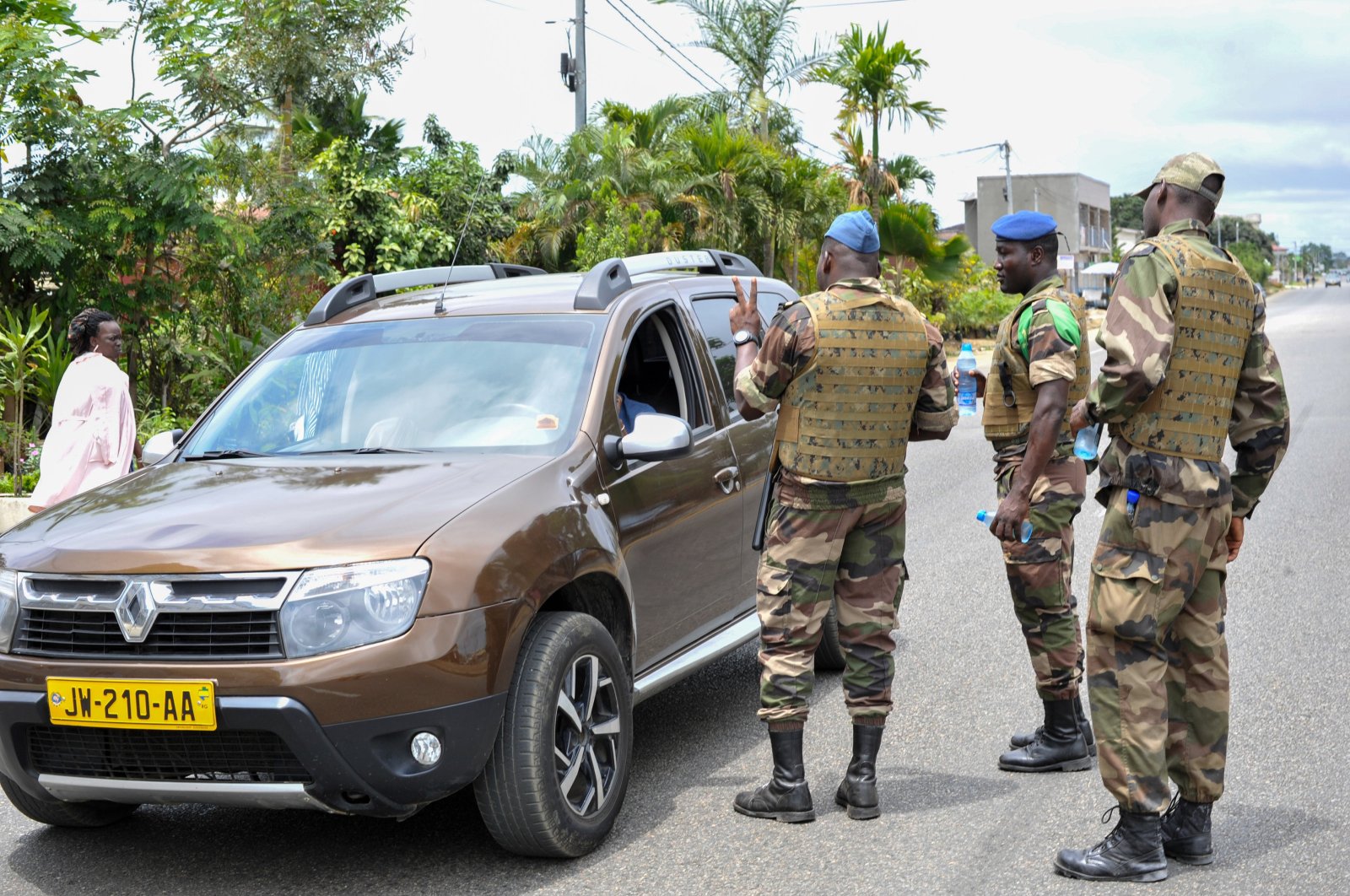 Members of the security forces gesture to a driver, at a checkpoint in the streets of Akanda, Gabon, Aug. 30, 2023. (EPA Photo)