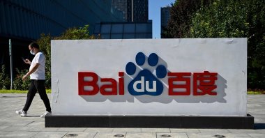 An employee walks past the company logo at Baidu's headquarters in Beijing, China, Sept. 6, 2022. (AFP Photo)