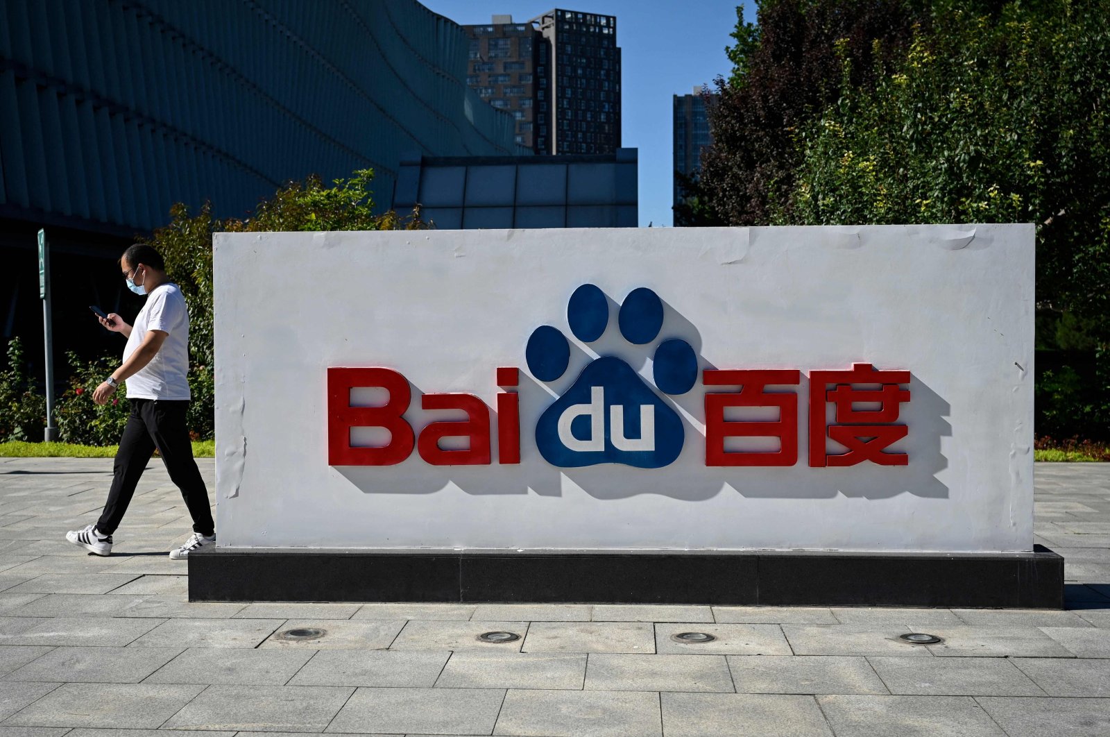 An employee walks past the company logo at Baidu&#039;s headquarters in Beijing, China, Sept. 6, 2022. (AFP Photo)