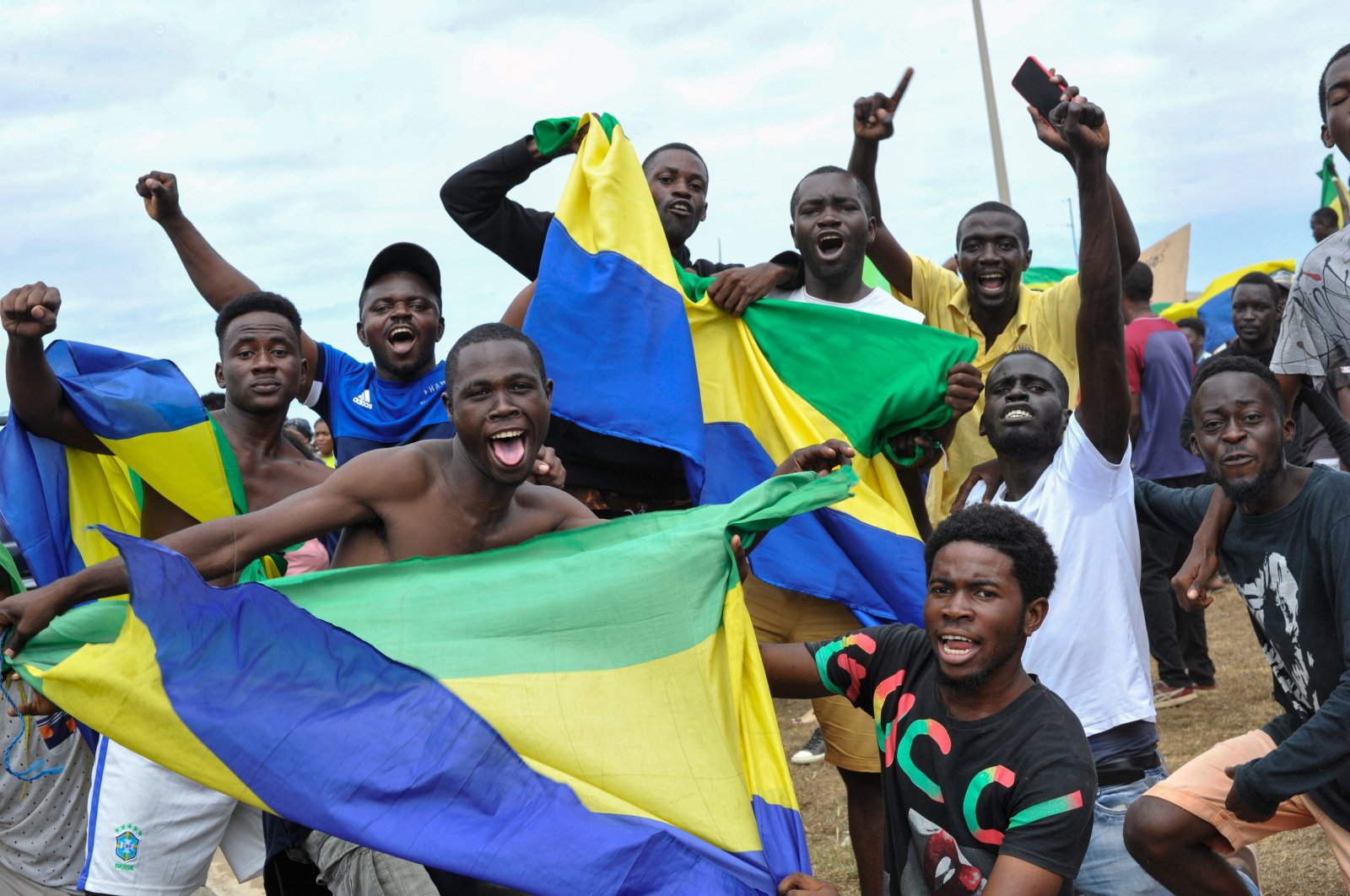 People wave Gabon national flags as they celebrate after a military coup, Akanda, Gabon, Aug. 30, 2023. (EPA Photo)