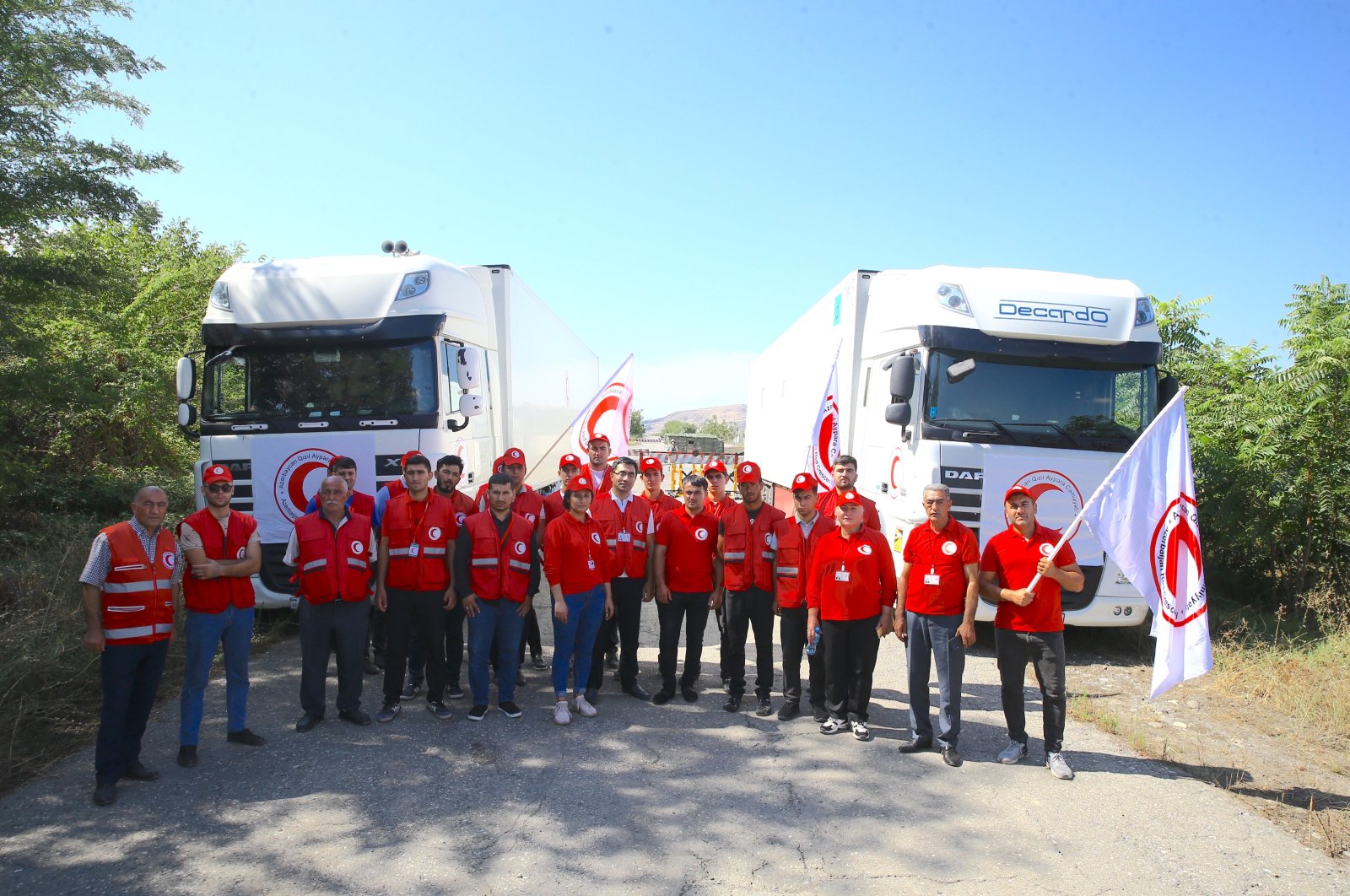 Azerbaijan Red Crescent Society poses in front of trucks laden with 40 tons of flour for the Armenian residents of Karabakh, awaiting passage at the border checkpoint of Russian peacekeeping forces in Karabakh, Azerbaijan, Aug. 31, 2023. (AA Photo)