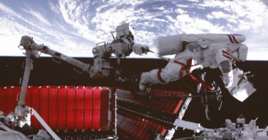 In this photo released by Xinhua News Agency, a video screen shows Chinese astronaut Fei Junlong conducting extravehicular activities on the orbiting Tiangong space station, Feb. 9, 2023. (AP Photo)