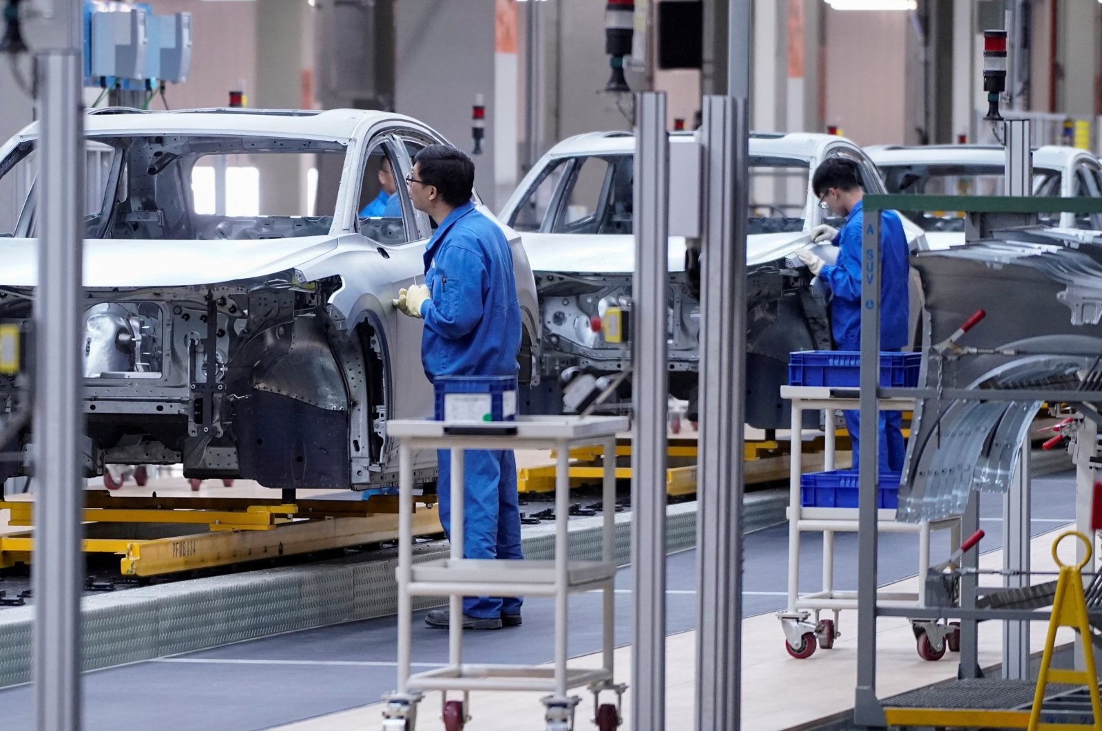 Employees work on the assembly line during a construction completion event of the SAIC Volkswagen MEB electric vehicle plant in Shanghai, China, Nov. 8, 2019. (Reuters Photo)