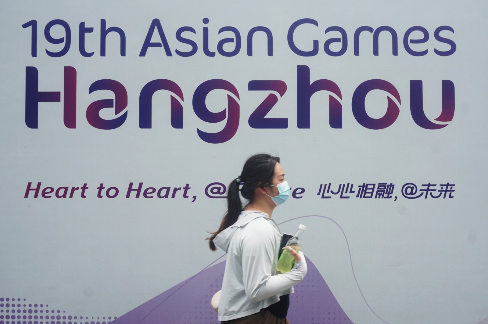 A citizen walks past a sign for the 19th Asian Games, Hangzhou, China, Aug. 24, 2023. (Getty Images Photo)