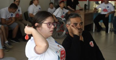 Turkish former wheelchair athlete teaches a youngster with Down syndrome to throw darts, Bursa, Türkiye, Sept. 5, 2023. (AA Photo)