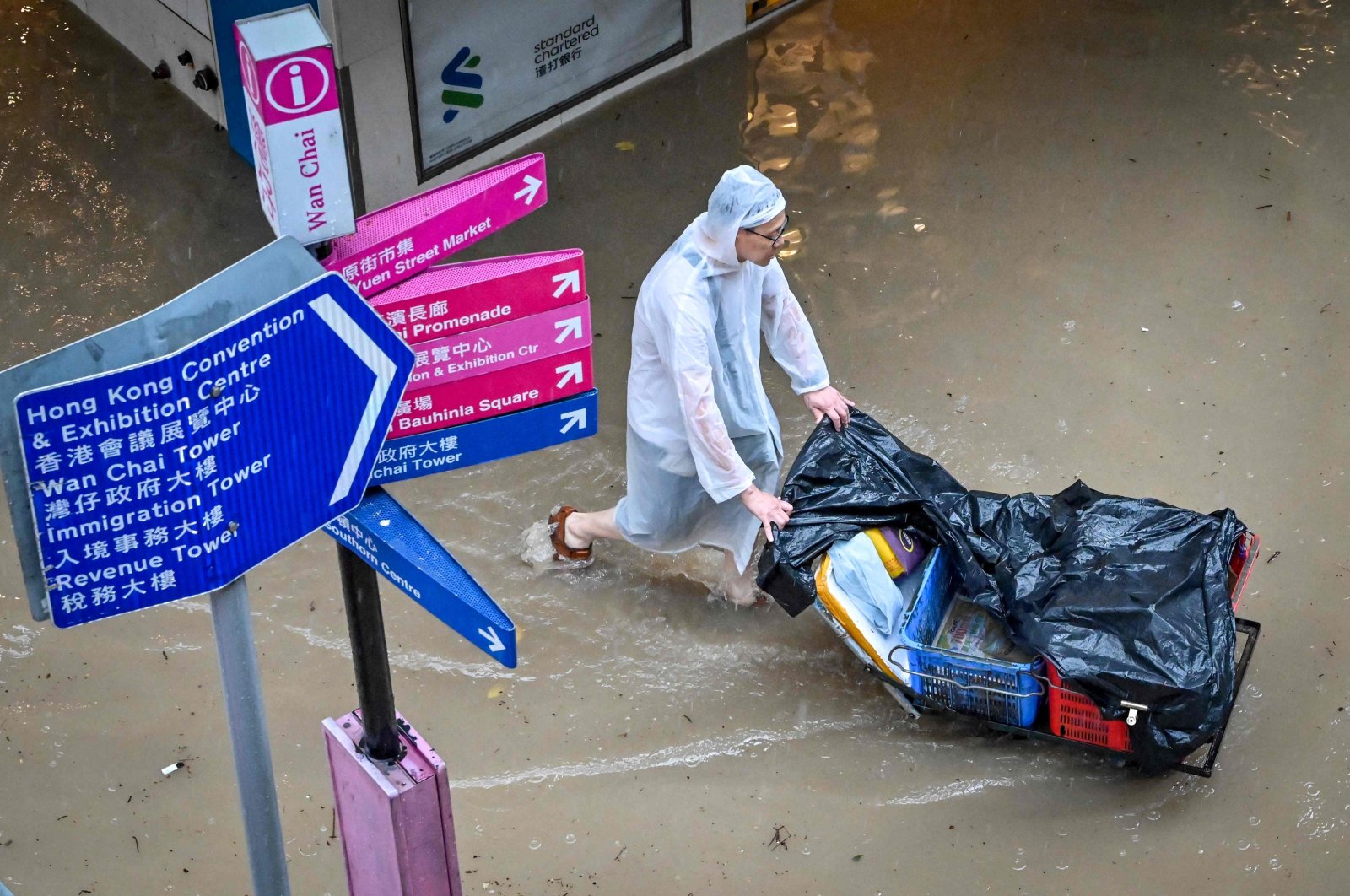 A man pushes a cart on a flooded road in Hong Kong, Sept. 8, 2023. (AFP Photo)