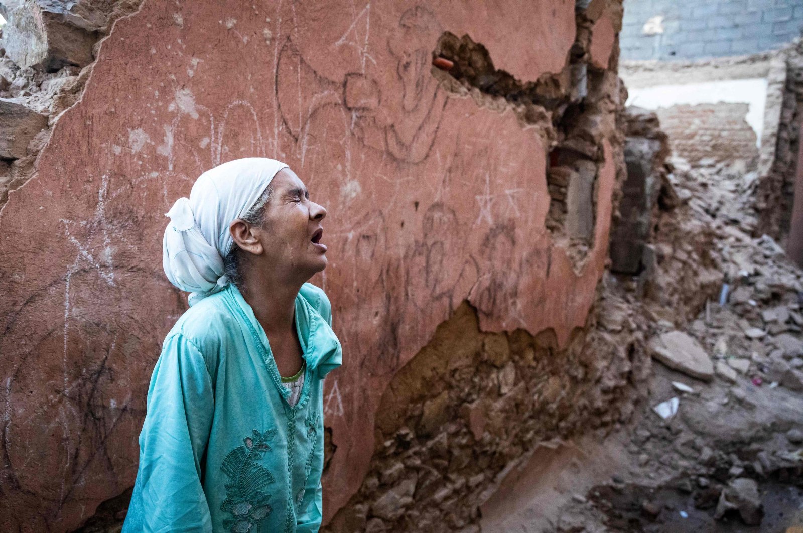 A woman reacts standing in front of her earthquake-damaged house in the old city in Marrakesh on Sept. 9, 2023. (AFP Photo)