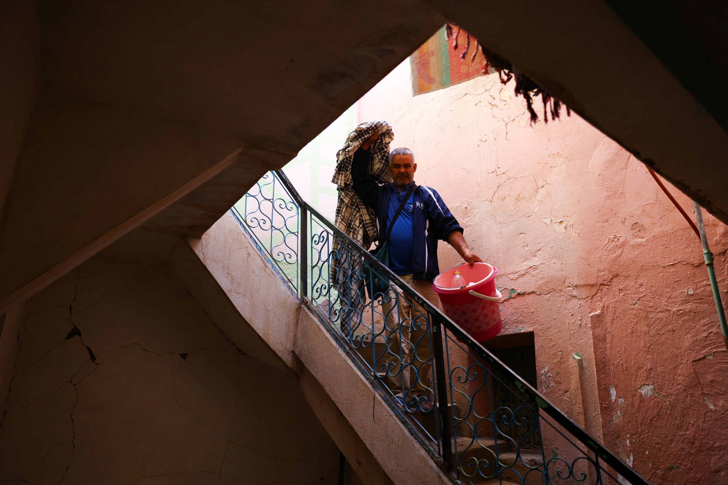 A man looks on as he carries belongings inside a damaged building, in the aftermath of a deadly earthquake in Moulay Brahim, Morocco, Sept. 10, 2023. (Reuters Photo)