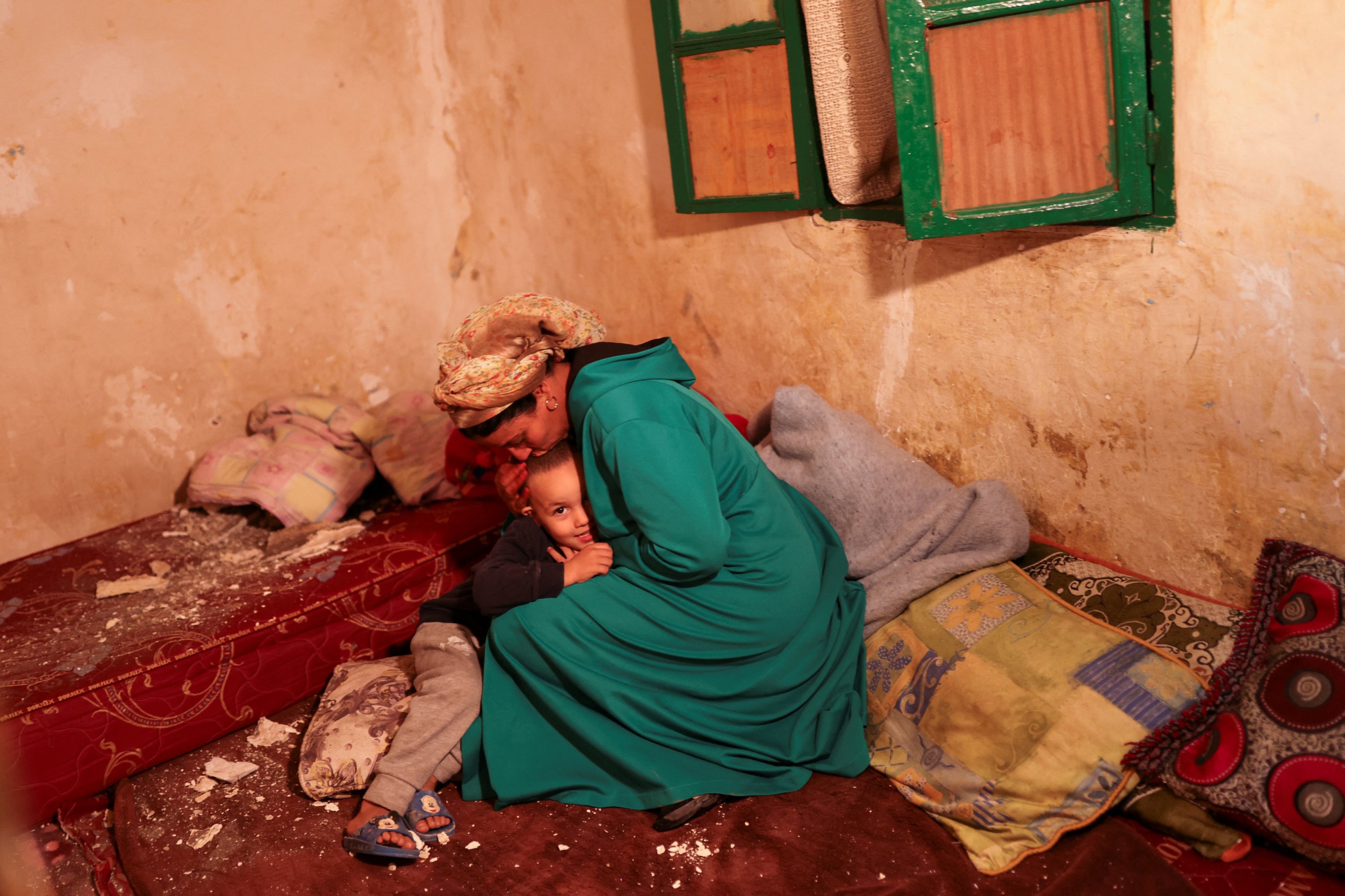 Hasna, 44, kisses her son Mohamed Jad, 5, inside their damaged house in Moulay Brahim village, Morocco, Sept. 9, 2023. (Reuters Photo)