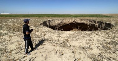 A man is seen standing close to a large sinkhole formed in the Karapınar district of central Konya province, Türkiye, Sept. 6, 2023. (AA Photo)