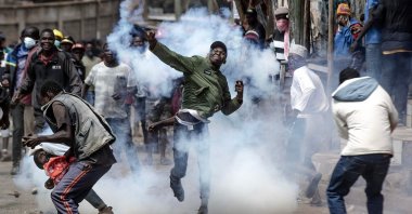 An opposition supporter throws a tear gas canister fired by anti-riot police during clashes with Kenya police officers during anti-government protests, Nairobi, Kenya, July 21, 2023. (AFP Photo)