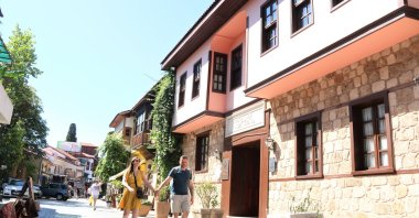 Tourists next to the old-fashioned stone houses in the historic Kaleiçi district, Antalya, southern Türkiye, Sept. 13, 2023. (IHA Photo)