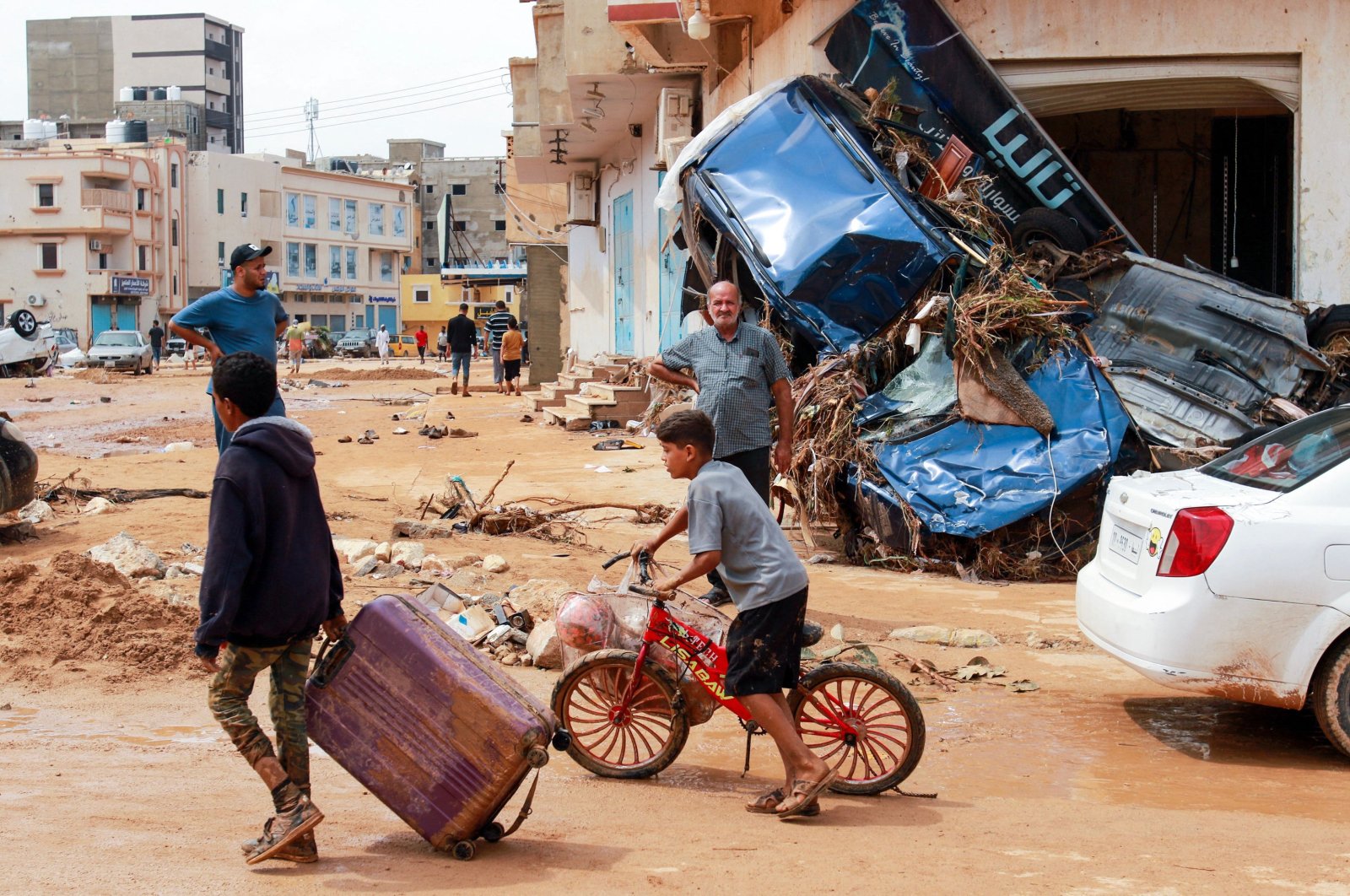 A boy pulls a suitcase past debris in a flash-flood damaged area in Derna, eastern Libya, on Sept. 11, 2023. (AFP Photo)