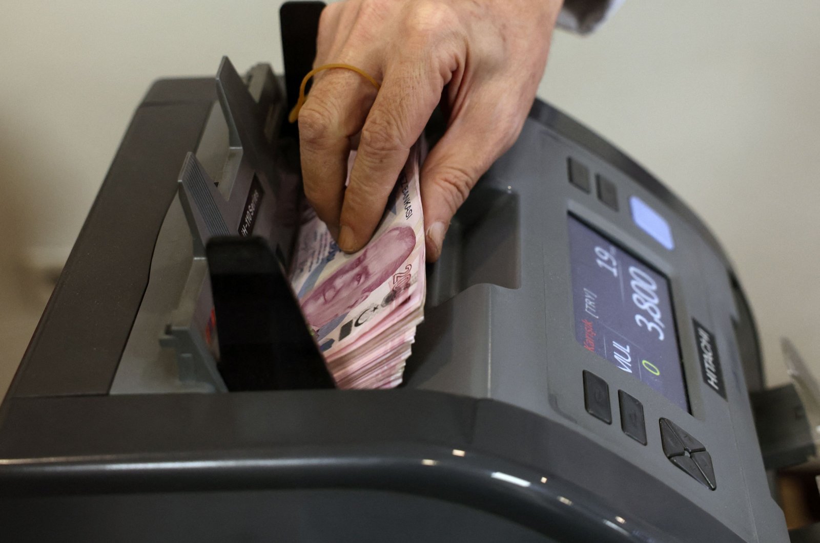 A teller uses a machine to count Turkish lira banknotes at a foreign exchange office in Ankara, Türkiye, July 20, 2023. (AFP Photo)