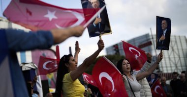 Supporters of President Recep Tayyip Erdoğan dance as they give handouts to commuters in Istanbul, Türkiye, May 23, 2023. (AP Photo)