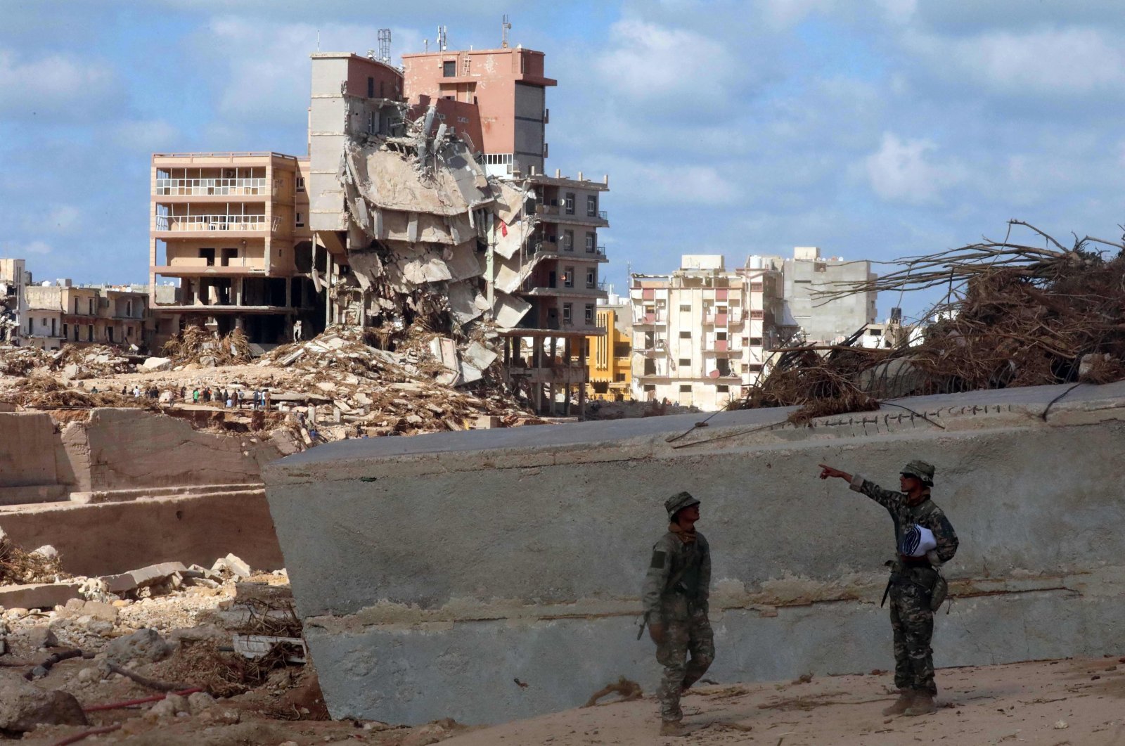 Soldiers stand in front of buildings destroyed in flash floods after the Mediterranean storm &quot;Daniel&quot; hit Libya&#039;s eastern city of Derna, on Sept. 14, 2023. (AFP Photo)