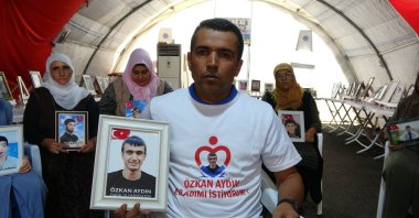 Süleyman Aydın holds the picture of his son Özkan who was 15 years old when he was kidnapped by the PKK, Diyarbakır, southeastern Türkiye, Aug. 26, 2023. (İHA Photo)