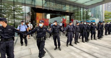 Security personnel form a human chain as they guard outside the Evergrande's headquarters, where people gathered to demand repayment of loans and financial products, in Shenzhen, Guangdong province, China, Sept. 13, 2021. (Reuters Photo)