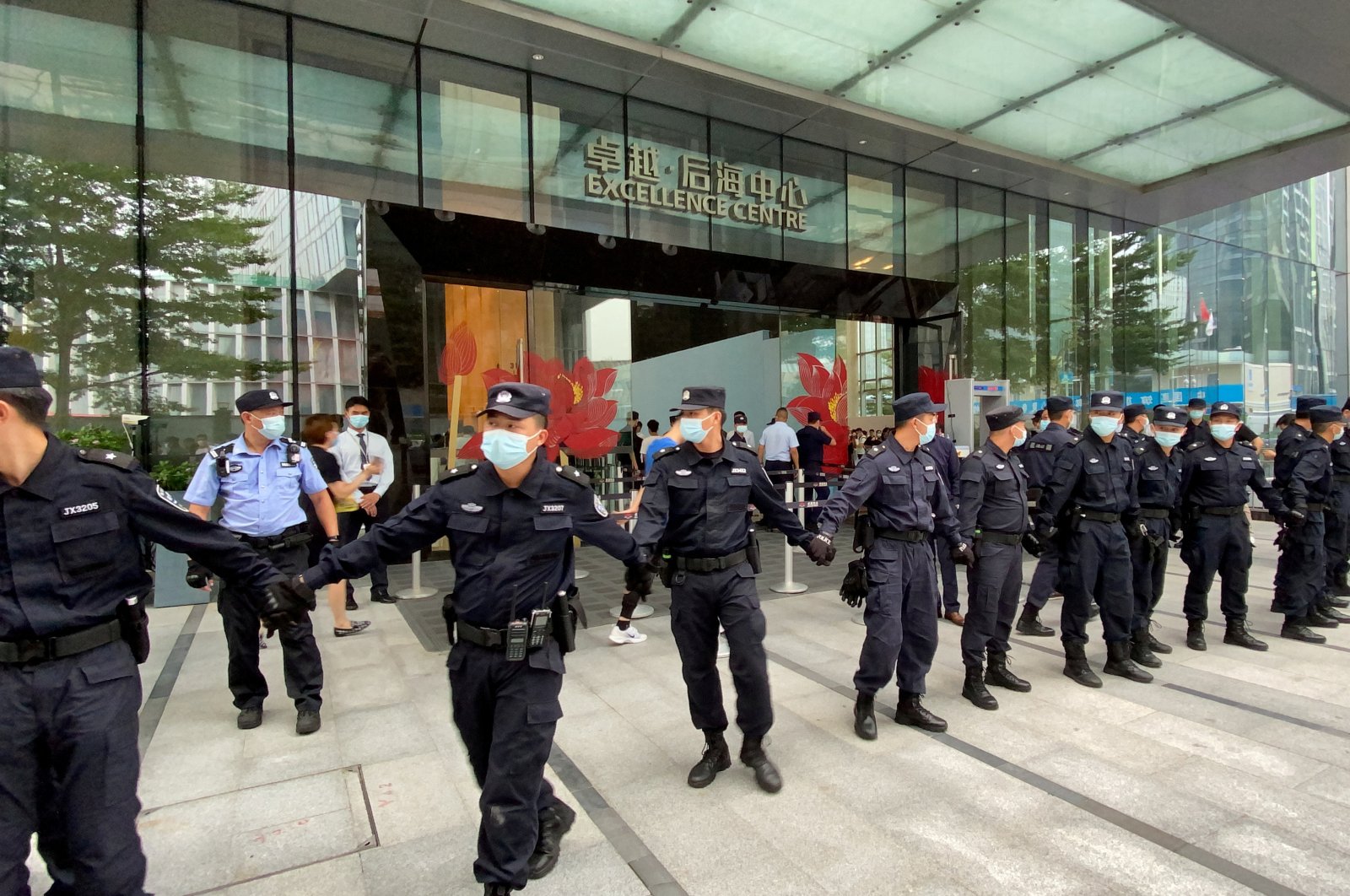 Security personnel form a human chain as they guard outside the Evergrande&#039;s headquarters, where people gathered to demand repayment of loans and financial products, in Shenzhen, Guangdong province, China, Sept. 13, 2021. (Reuters Photo)
