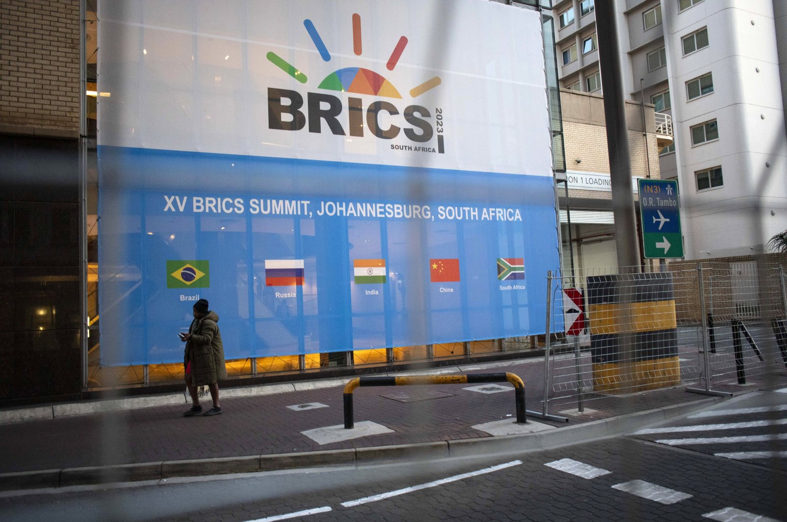 A man walks past a banner as final preparations are underway for the 15th BRICS Summit at the Sandton Convention Centre, Johannesburg, South Africa, Aug. 21, 2023. (EPA Photo)