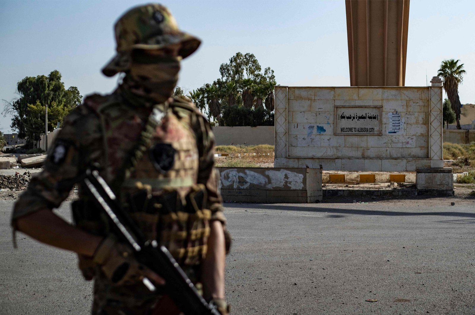 An SDF terrorist stands guard along a road as others deploy to impose a curfew in the town of al-Busayrah in Syria&#039;s northeastern Deir el-Zour province on Sept. 4, 2023. (AFP File Photo)