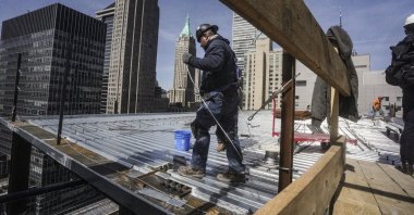 Construction workers install roofing on a high rise in Manhattan&#039;s financial district in New York, U.S., April 11, 2023. (AP Photo)