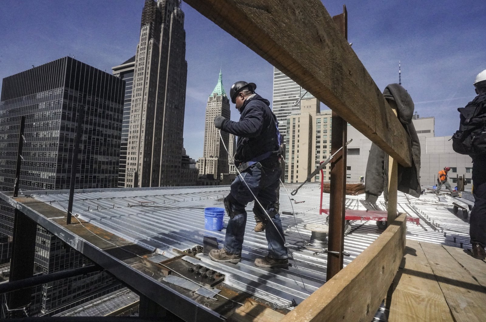 Construction workers install roofing on a high rise in Manhattan&#039;s financial district in New York, U.S., April 11, 2023. (AP Photo)
