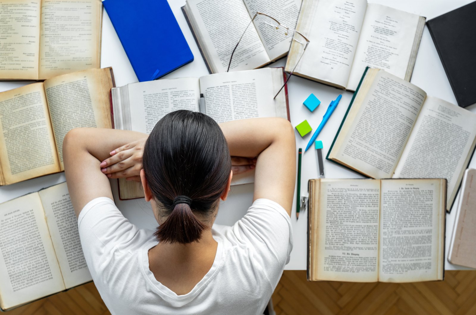 A tired university student rests while doing homework at her desk in this undated file photo. (Getty Image File Photo)