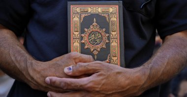 A protester holds the Quran during a rally in Beirut, Lebanon, Friday, July 21, 2023. (AP Photo)