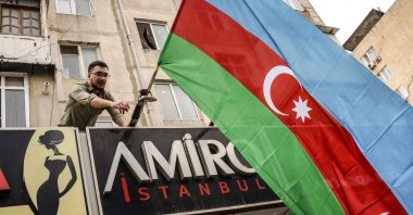 An Azerbaijani resident hangs a state flag in support of the country&#039;s offensive in the Karabakh region, in Baku, Azerbaijan on September 20, 2023. (AFP Photo)