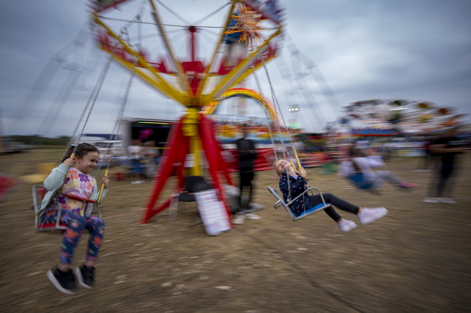 Children enjoy a swing ride at a fair in Hagioaica, Romania, Sept. 16, 2023. (AP Photo)
