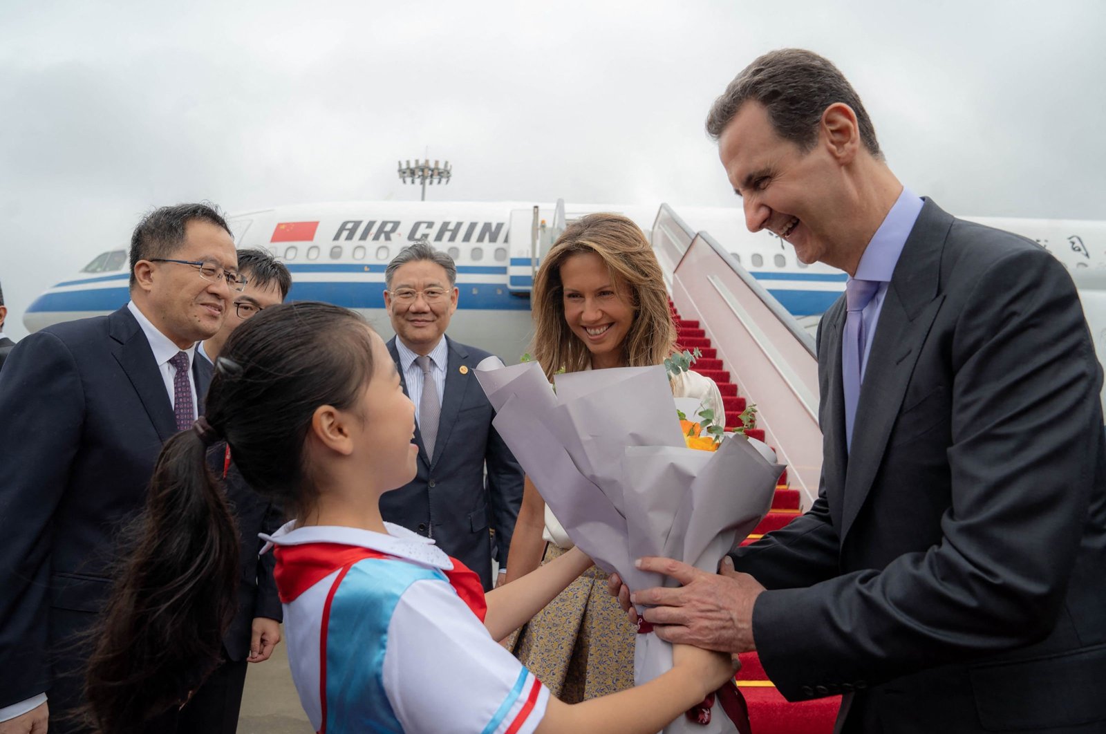 Syria&#039;s President Bashar al-Assad (R) his spouse Asma al-Assad (2-R) being welcomed upon their arrival at the airport, Beijing, China, Sept. 21, 2023. (AFP Photo)