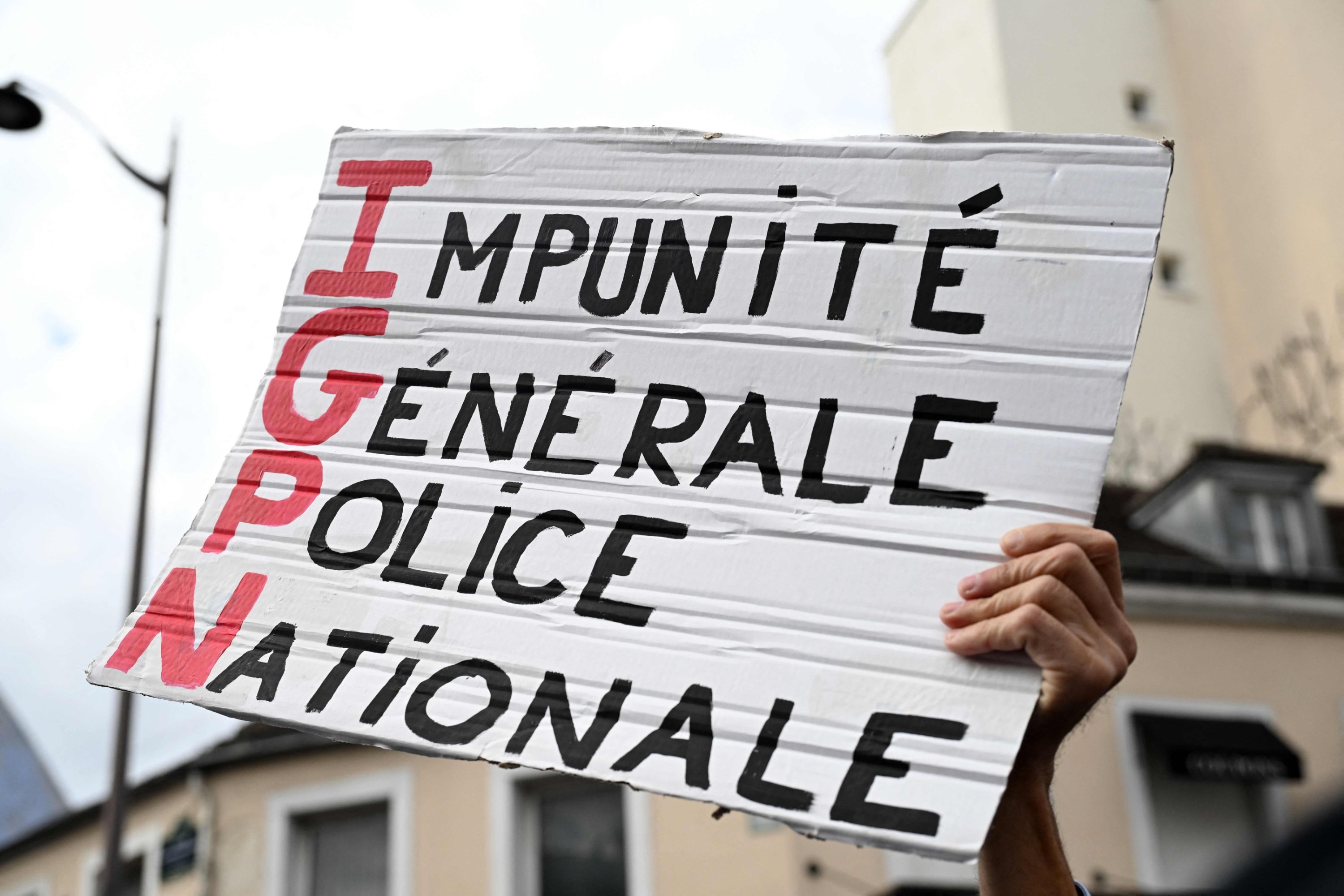A protestor holds a slogan which reads in French 