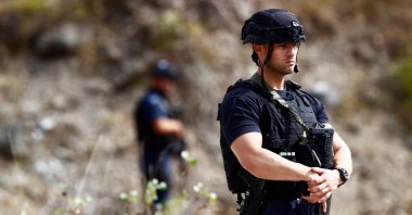 A police officer stands guard in the aftermath of a shooting, near the village of Zvecane, Kosovo September 24, 2023. (Reuters Photo)
