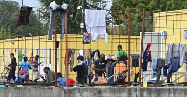 Migrants dry their clothes on a fence at the Red Cross reception center in Via Tres, Turin, Italy, Sept. 20, 2023. (EPA Photo)