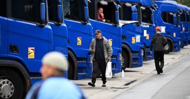Truck drivers walk past parked trucks outside Frankfurt am Main, western Germany, Sept. 22, 2023. (AFP Photo)