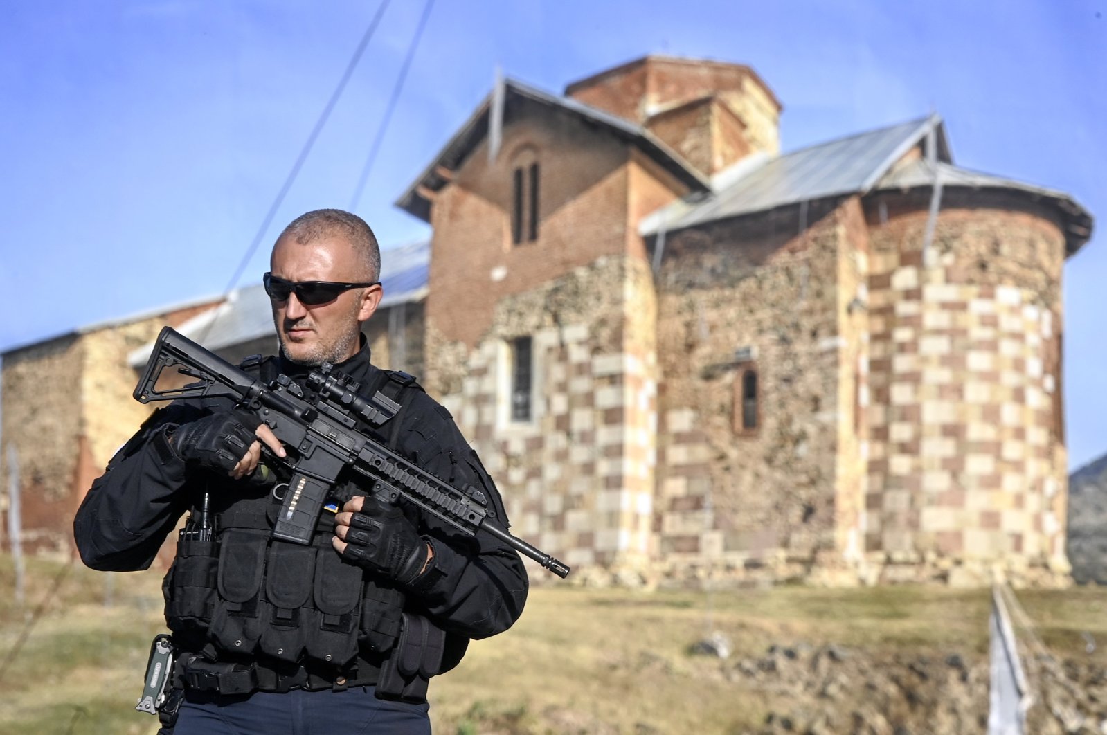 An armed Kosovo police officer stands guard along a road near the village of Banjska, Kosovo, Sept. 26, 2023. (EPA Photo)