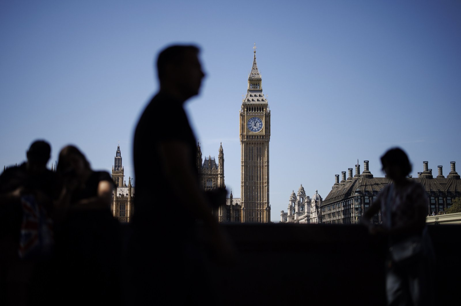 People walk along the Southbank with The Palace of Westminster, home to the Houses of Parliament in the background, in London, Britain, Sept. 4, 2023. (EPA Photo)