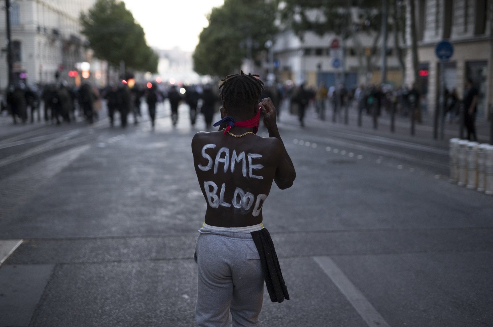 A protester with the words &quot;same blood&quot; painted on his back faces French riot police during a march against police brutality and racism in Marseille, France, June 13, 2020. (AP Photo)