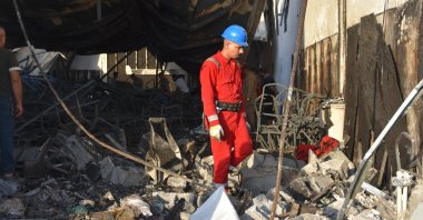 A firefighter scans through the rubble of the building burned down by the fire in Mosul, Iraq, Sept. 27, 2023. (AA Photo)