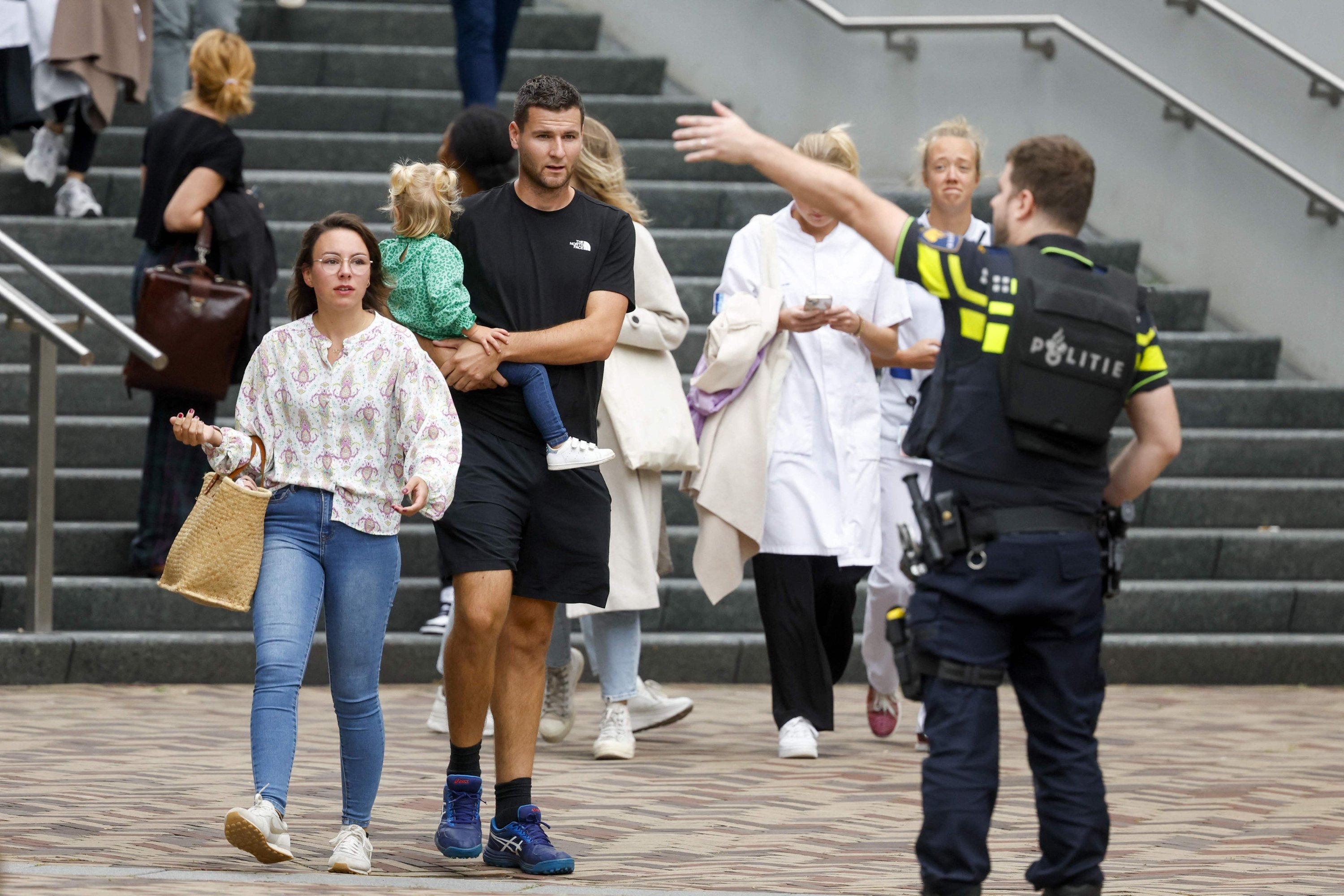 Netherlands police officer directs bystanders from an entrance to the Erasmus University Medical Center (Erasmus MC), which was cordoned off after two reported shooting incidents, in Rotterdam, Netherlands, Sept. 28, 2023. (AFP Photo)