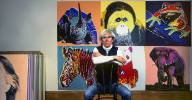 American pop artist Andy Warhol sits in front of several paintings in his &quot;Endangered Species&quot; series at his studio, the Factory, in Union Square, New York, U.S., April 12, 1983. (Getty Images Photo)
