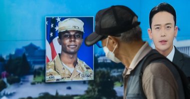 A man walks past a television showing a news broadcast featuring a photo of U.S. soldier Travis King (C), who ran across the border into North Korea, in Seoul, South Korea, Aug. 16, 2023. (AFP Photo)