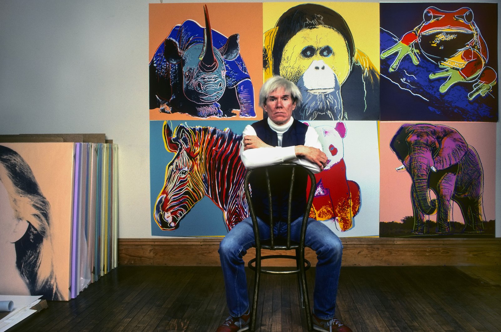 American pop artist Andy Warhol sits in front of several paintings in his &quot;Endangered Species&quot; series at his studio, the Factory, in Union Square, New York, U.S., April 12, 1983. (Getty Images Photo)
