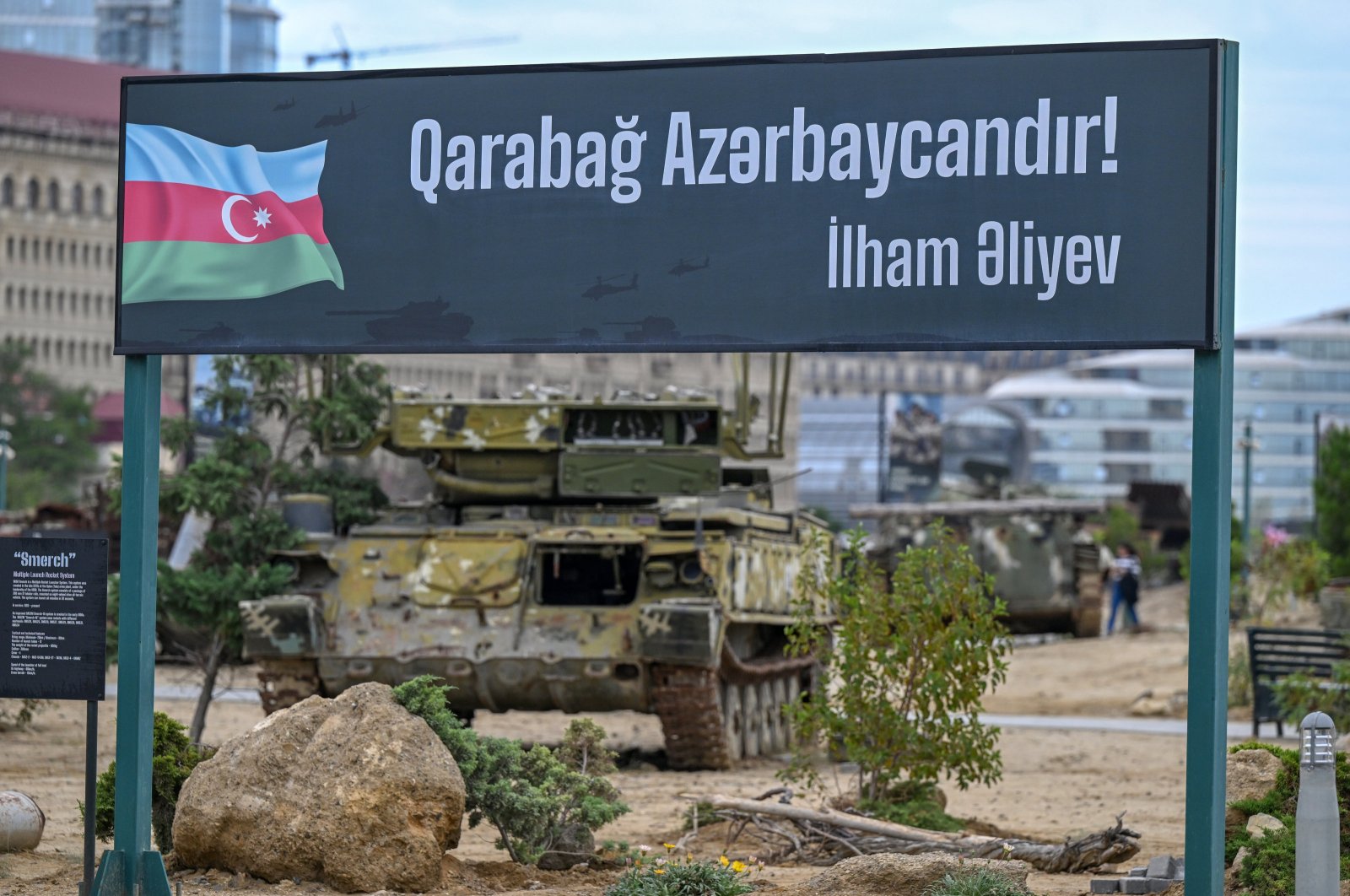 People walk next to a poster &quot;Karabakh is Azerbaijan! Ilham Aliev&quot; at the Military Trophy Park, containing war trophies seized by the Armed Forces of Azerbaijan during the 2020 Karabakh conflict, Baku, Azerbaijan, Sept. 27, 2023.(AA Photo)