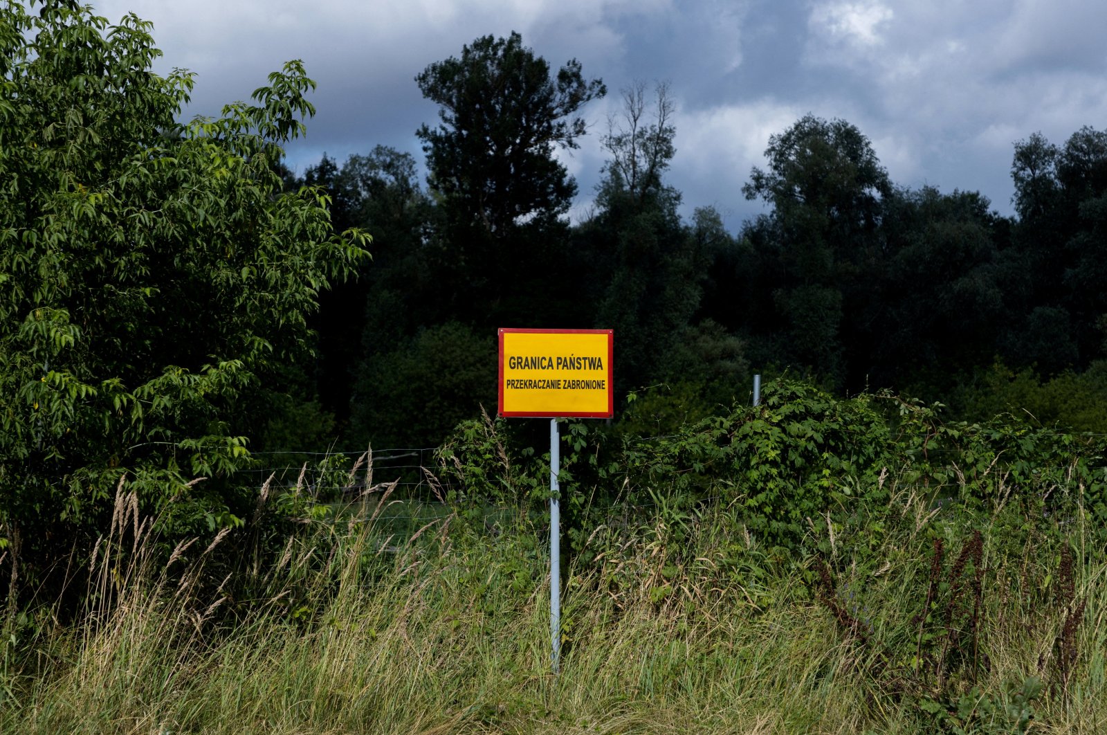 A sign reading &quot;State border. Crossing prohibited&quot; is seen near the Bug River at the Poland-Belarus border, near Kostomloty, Poland, July 20, 2023. (Reuters Photo)