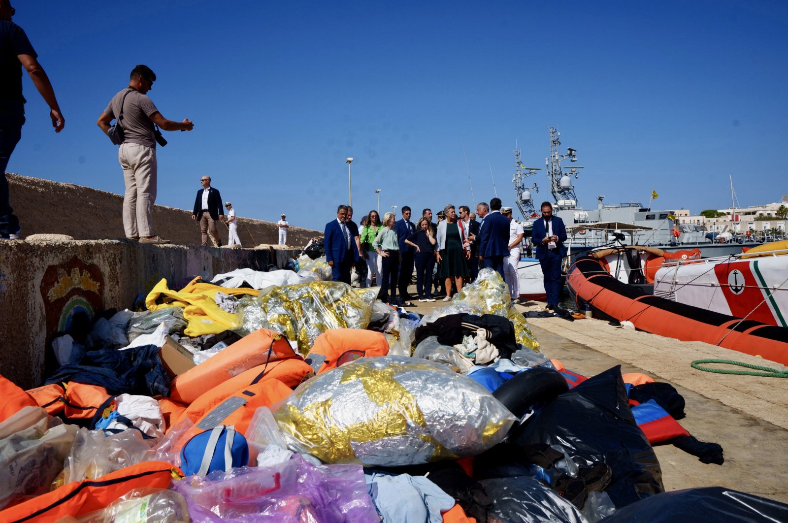 A handout photo made available by CHIGI PALACE PRESS OFFICE shows Italian Premier Giorgia Meloni, EU Commission President Ursula von der Leyen watching the dozens of small boats moored in front of the quay, on which hundreds of migrants have arrived in recent weeks, in Lampedusa, Italy, Sept. 17, 2023. (EPA File Photo)